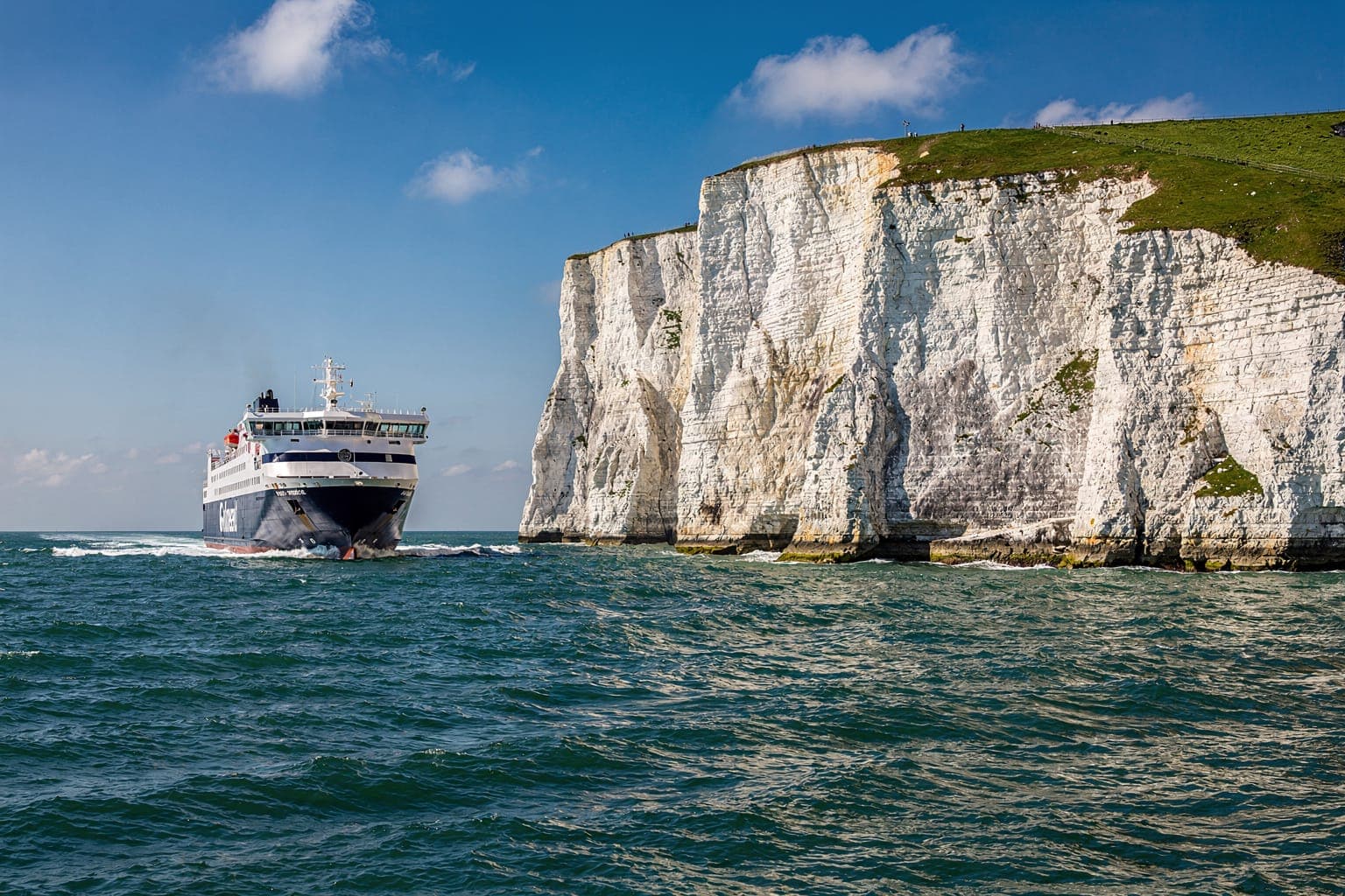 A car ferry sailing past the white cliffs of Dover